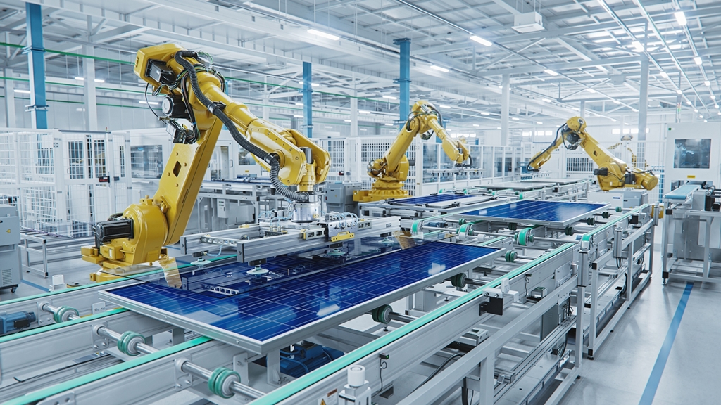 Robotic arms assembling photovoltaic solar panels in a factory line