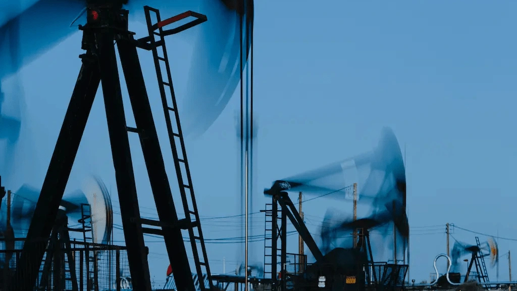 Oil Derricks at Work Against Blue Sky