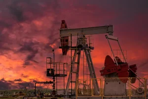 Oil Pumpjack at Sunset Against Dramatic Sky