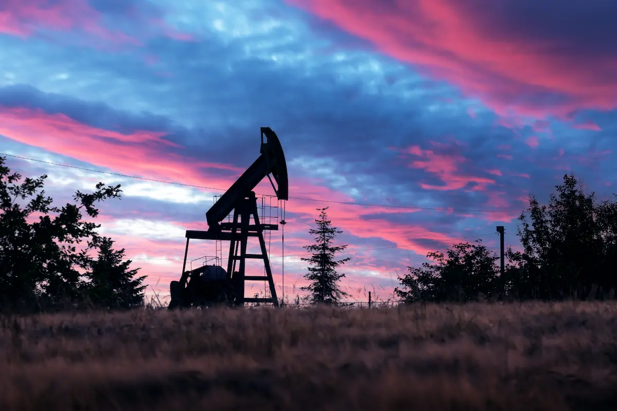 Pump jack silhouette on evening field